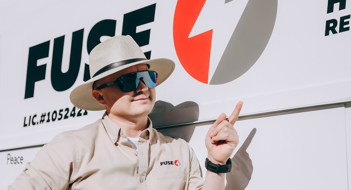 Руслан Хусніяров показує пальцем на лого компанії Fuse Service